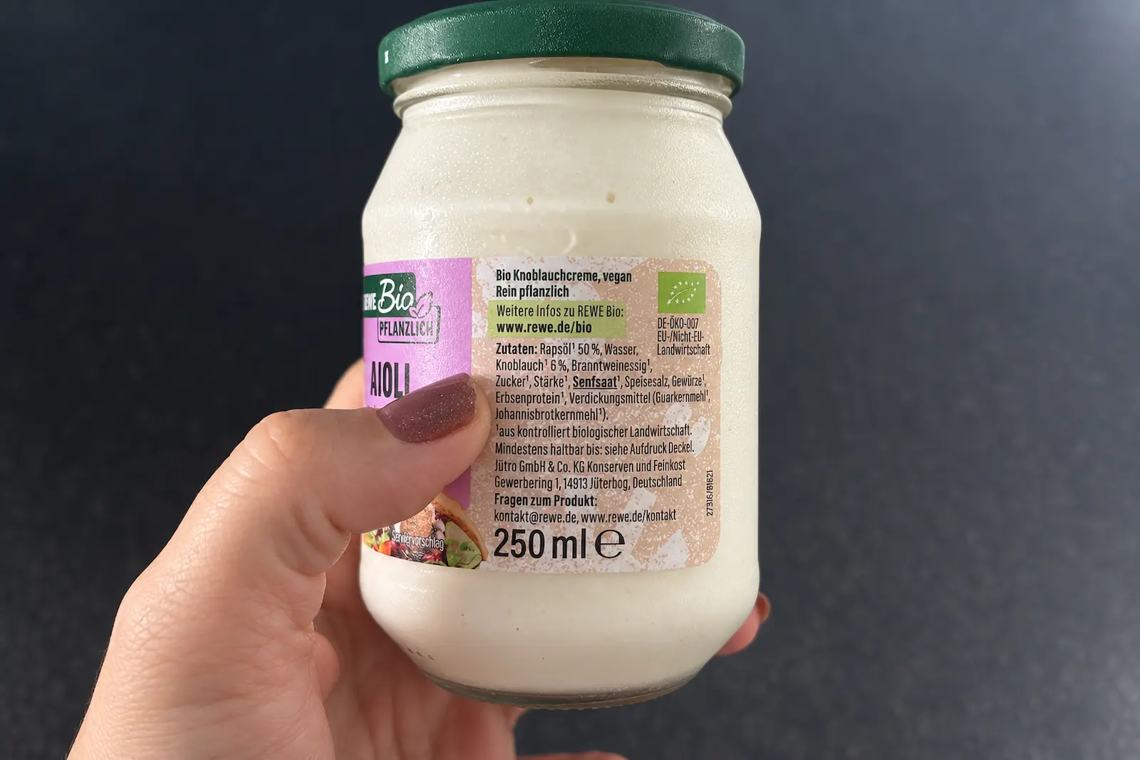 Hand hält ein Lebensmittel im Supermarkt und prüft die Zutatenliste – Einkaufen mit Lebensmittelallergie