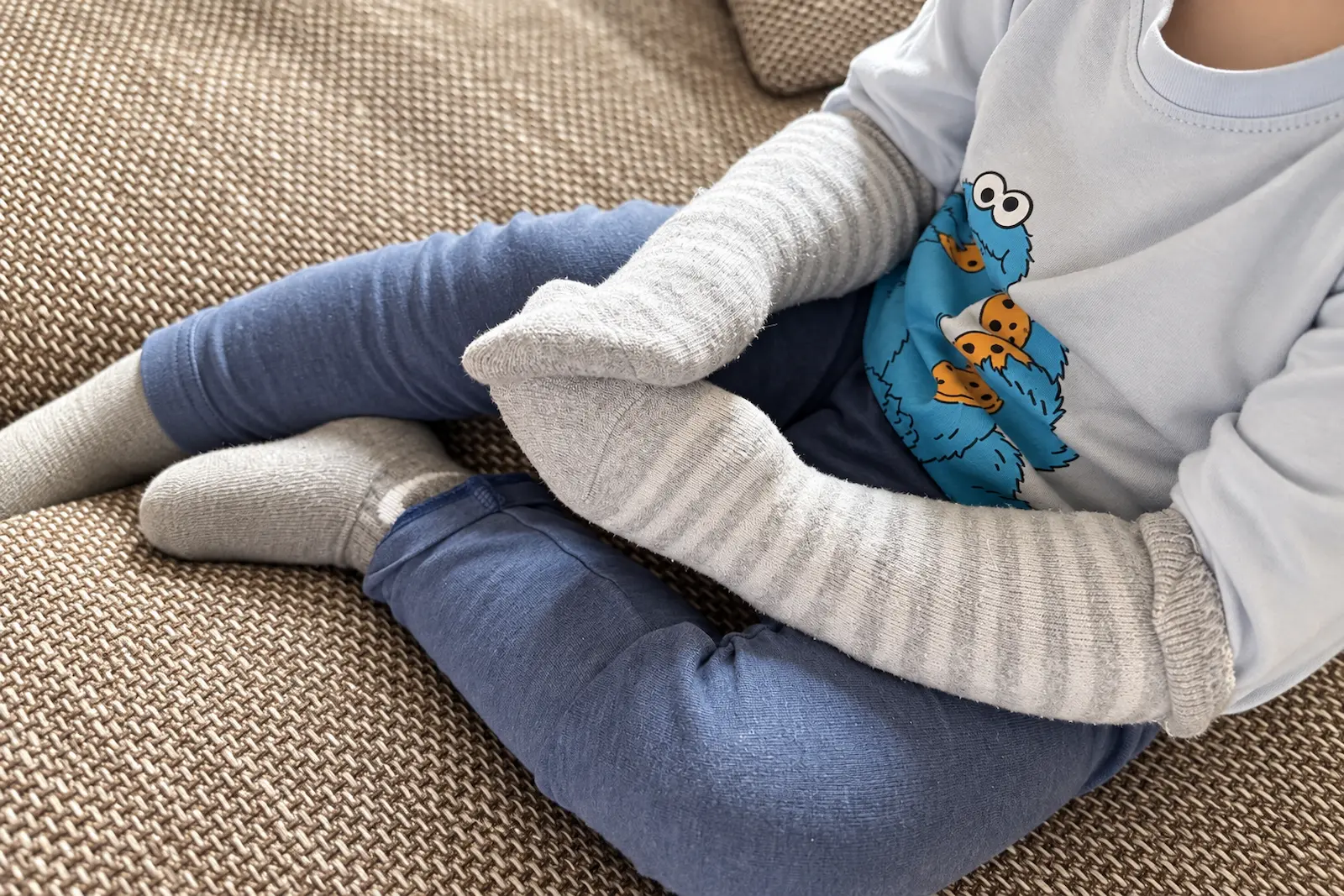 Lange Socke als Kratzschutz über den Arm eines Kindes gestülpt, bis zum Ellenbogen – der Socken-Trick bei Neurodermitis